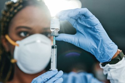 Een verpleegster maakt een vaccin klaar.